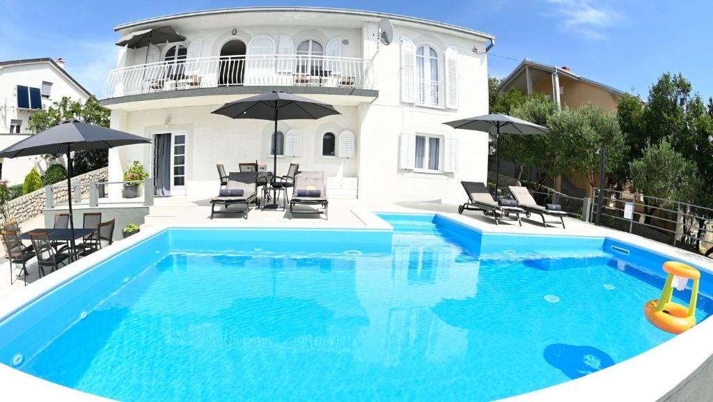 a swimming pool in front of a house at My Day House App1 in Klenovica