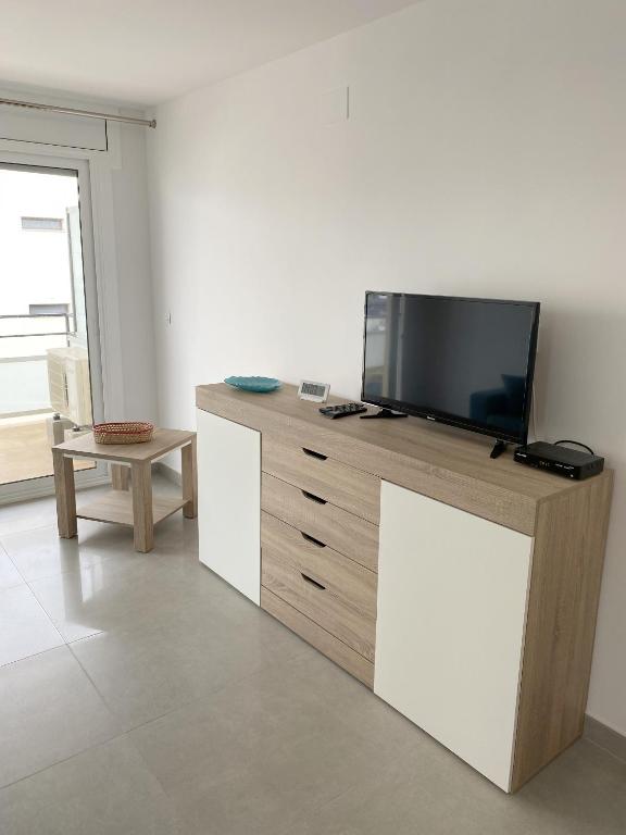 Televízia a/alebo spoločenská miestnosť v ubytovaní Roses I