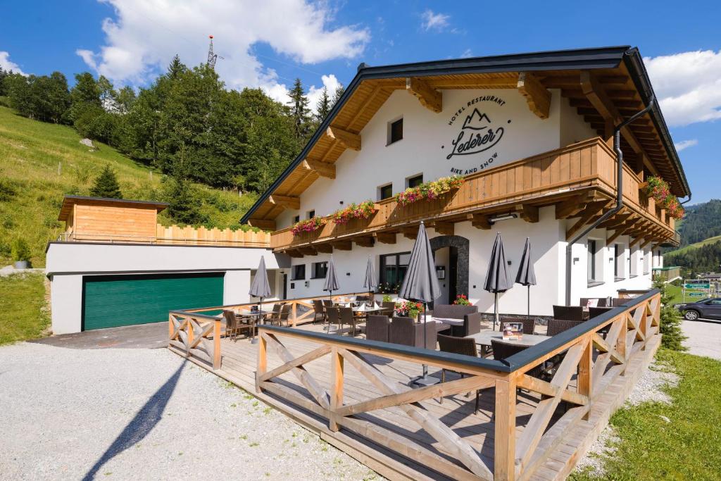 ein Gebäude mit einem Holzzaun davor in der Unterkunft Hotel-Restaurant Bike&Snow Lederer in Mühlbach am Hochkönig