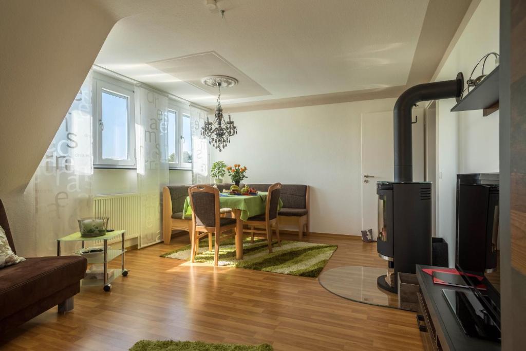 uma sala de estar com uma mesa e um sofá em Ferienwohnung Schürer em Meckenbeuren