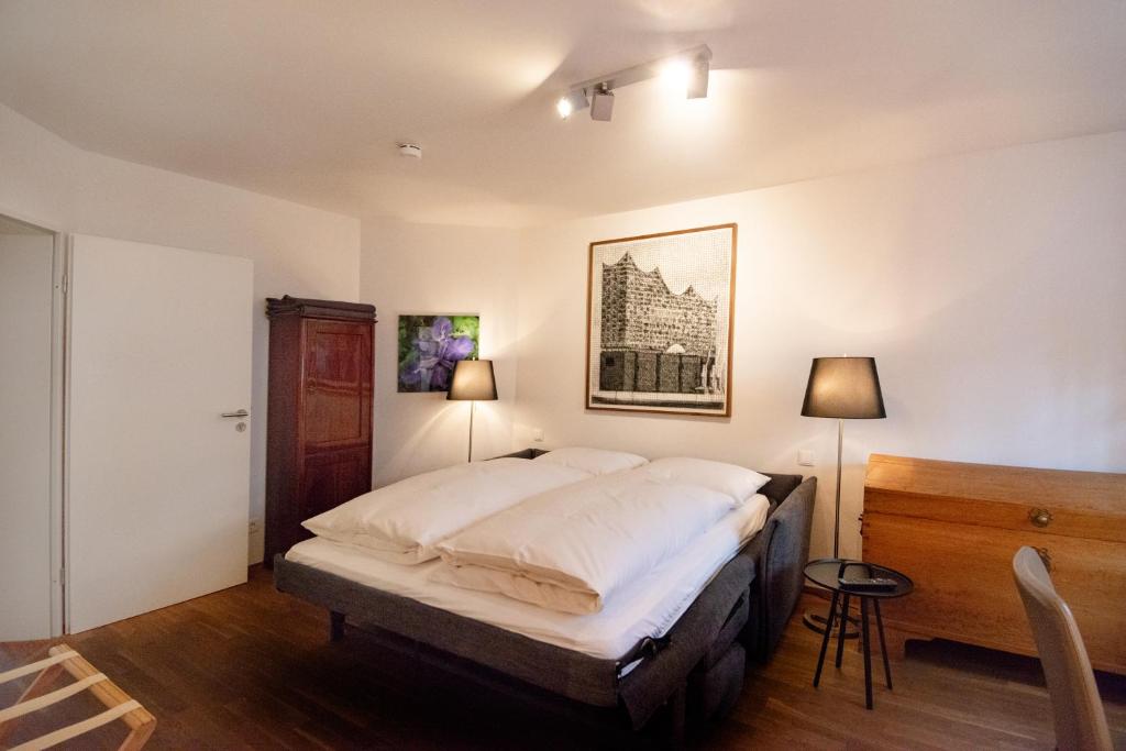 a bedroom with a bed and a table and two lamps at FirstClass Apartments in Hamburg