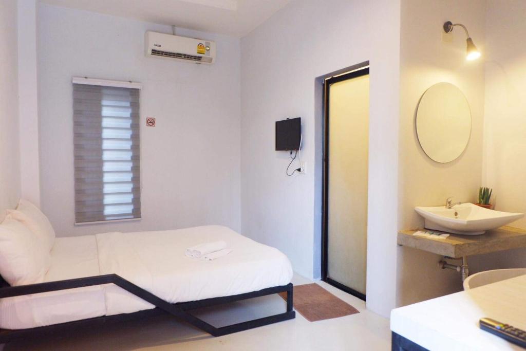 bagno con letto, lavandino e specchio di Get เกสต์เฮ้าส์ ประชารักษ์ a Hat Yai