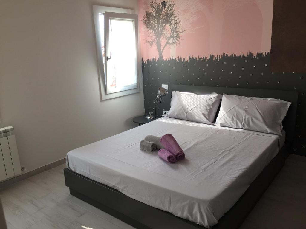 sypialnia z łóżkiem z fioletowym łukiem w obiekcie Altana Deluxe Apart w mieście Chioggia