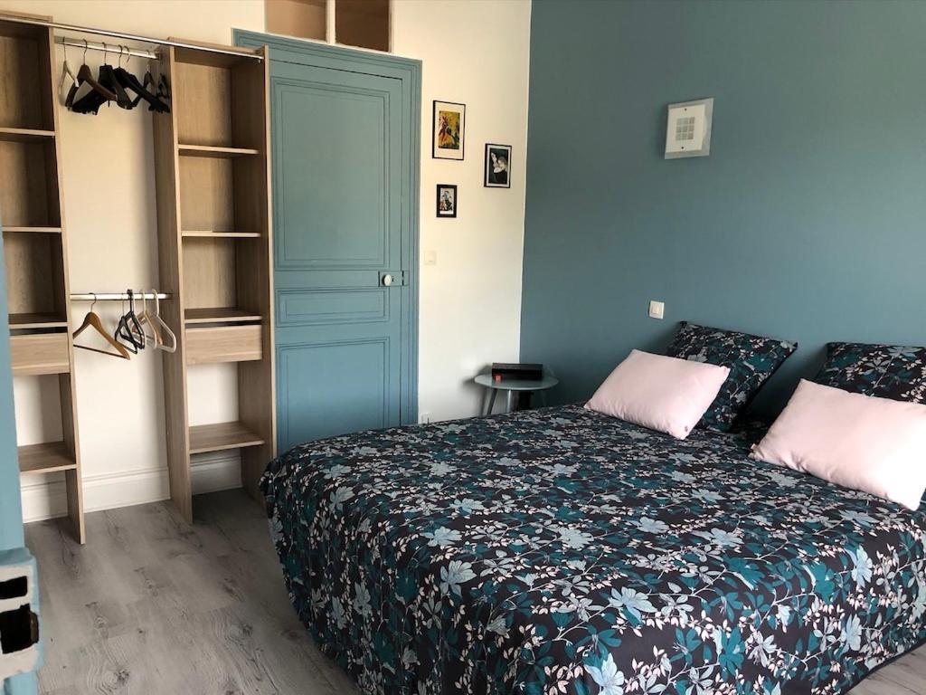 ein Schlafzimmer mit einem Bett und einer blauen Tür in der Unterkunft JOANN in Wimereux