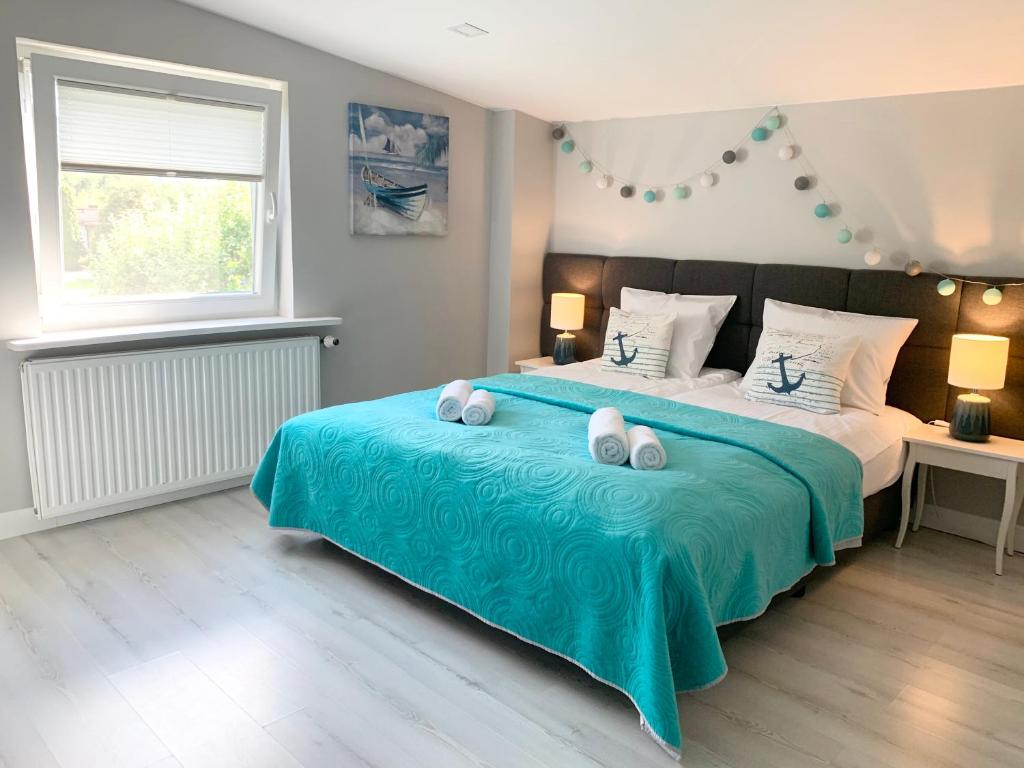 ein Schlafzimmer mit einem großen Bett mit einer blauen Decke in der Unterkunft Toscana in Łódź