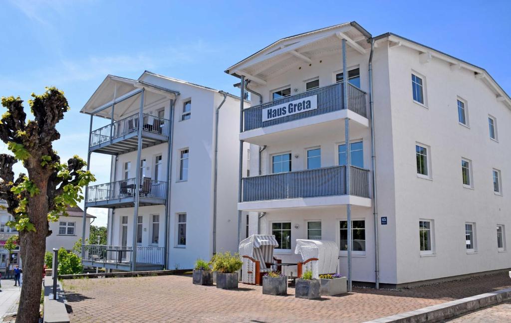 un edificio blanco con un cartel. en Appartementhaus Greta im Ostseebad en Ostseebad Sellin