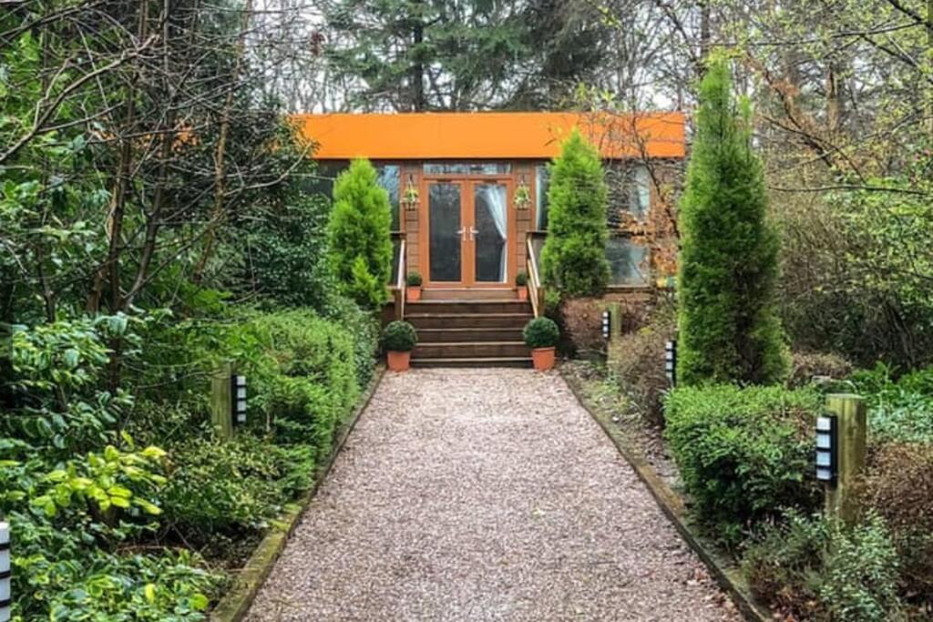 uma casa com um telhado laranja e um caminho que leva até ela em Relaxing secluded lodge couples getaway with hot tub em Eaton