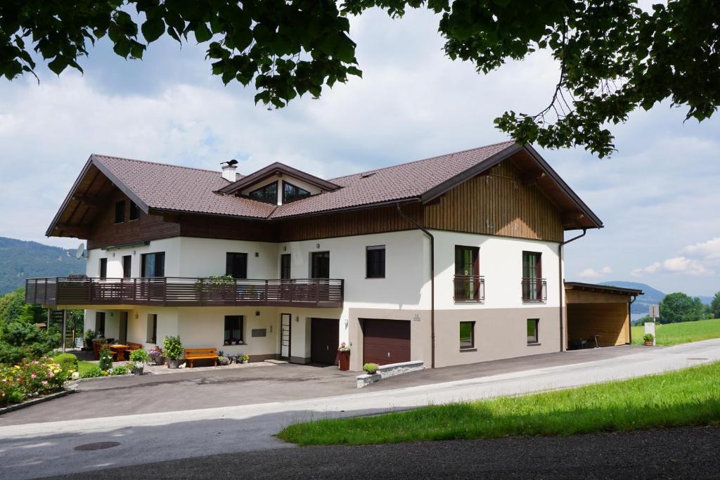 een groot wit huis met een bruin dak bij Ferienwohnung Hausleitner in Zell am Moos