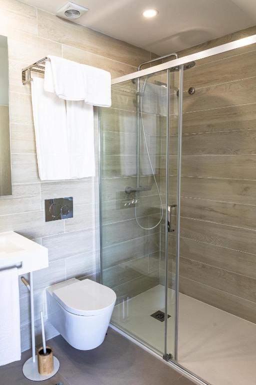 a bathroom with a shower with a toilet and a sink at Lagos Atlantic Hotel in Lagos