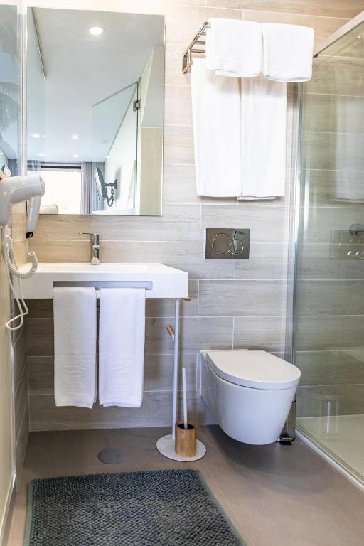 a bathroom with a toilet and a sink and a shower at Lagos Atlantic Hotel in Lagos