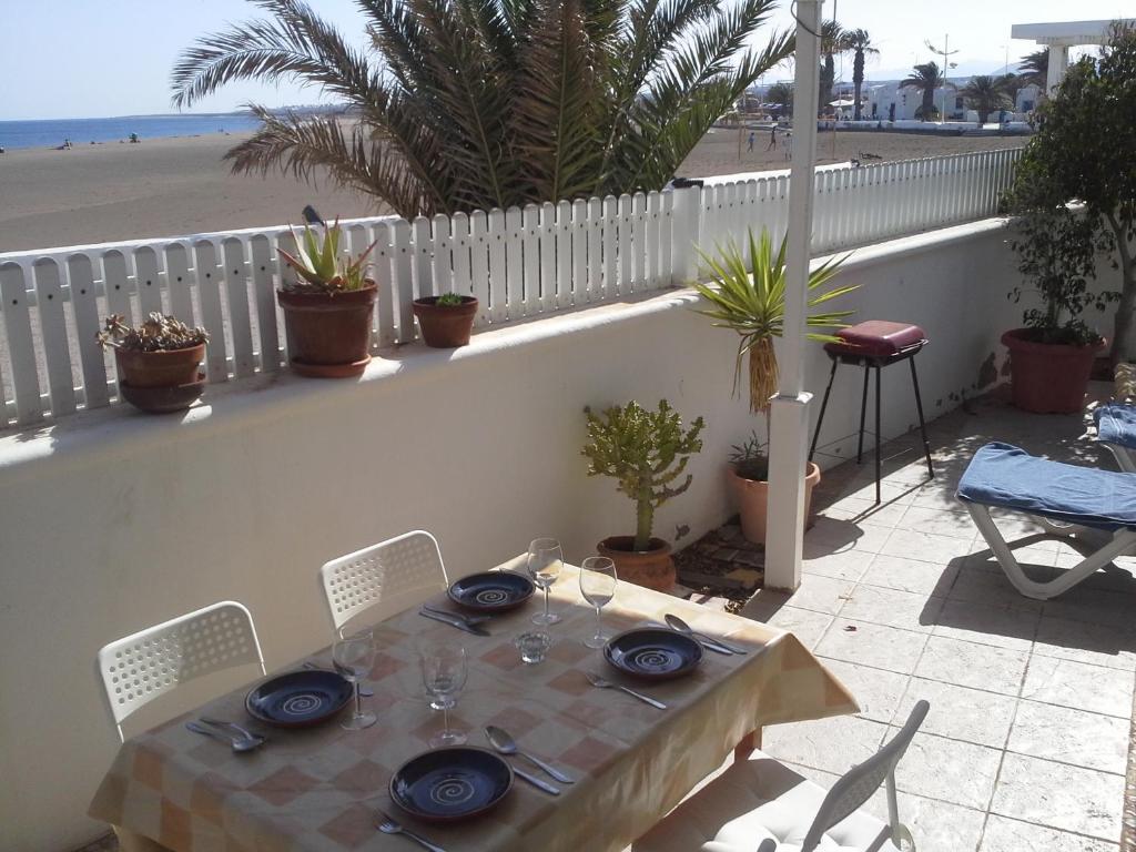 a table with blue plates and chairs and a beach at Villa Mela in Playa Honda