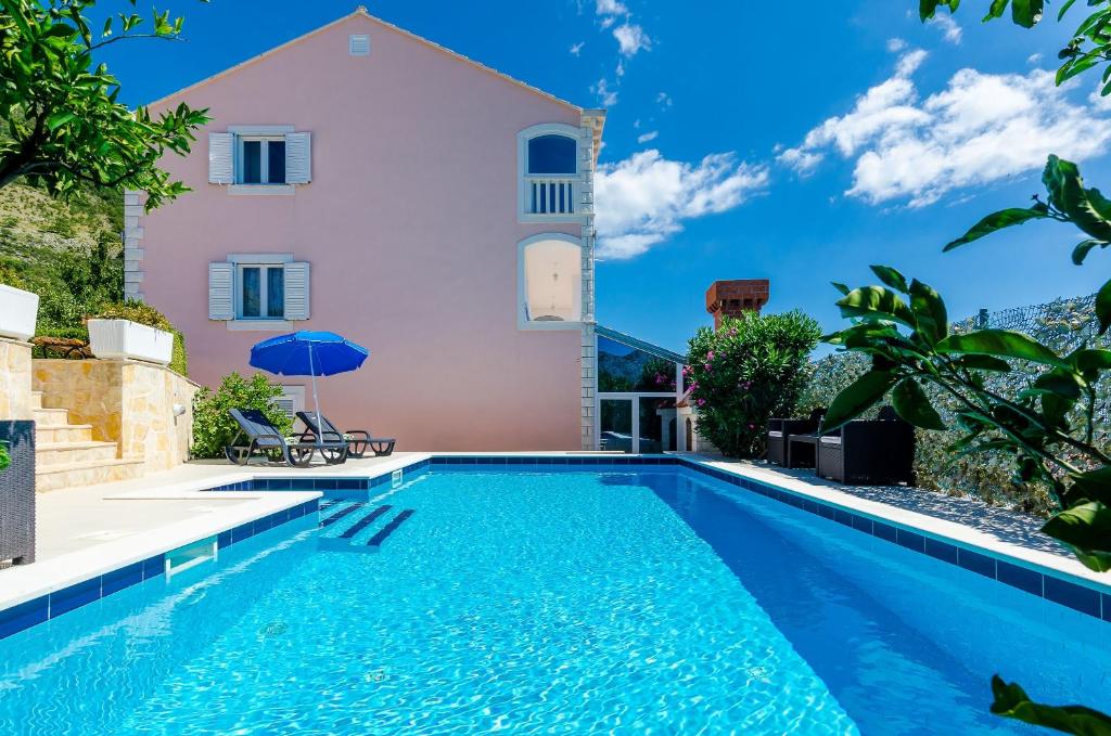 a villa with a swimming pool in front of a house at Villa Mateo with Private Pool in Gruda