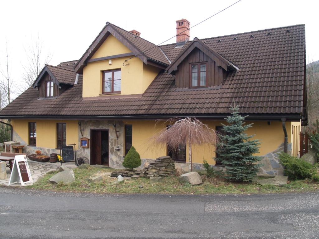 a yellow house with a brown roof at Penzion Gutská krčma in Třinec