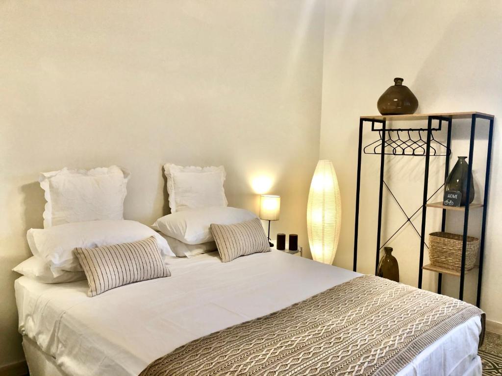 a bedroom with a white bed with two pillows at Barrique Guest House in Palermo