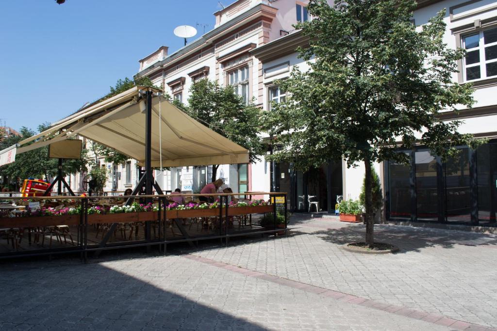 a restaurant with a tan umbrella and tables at Hostel Theater 011 in Belgrade