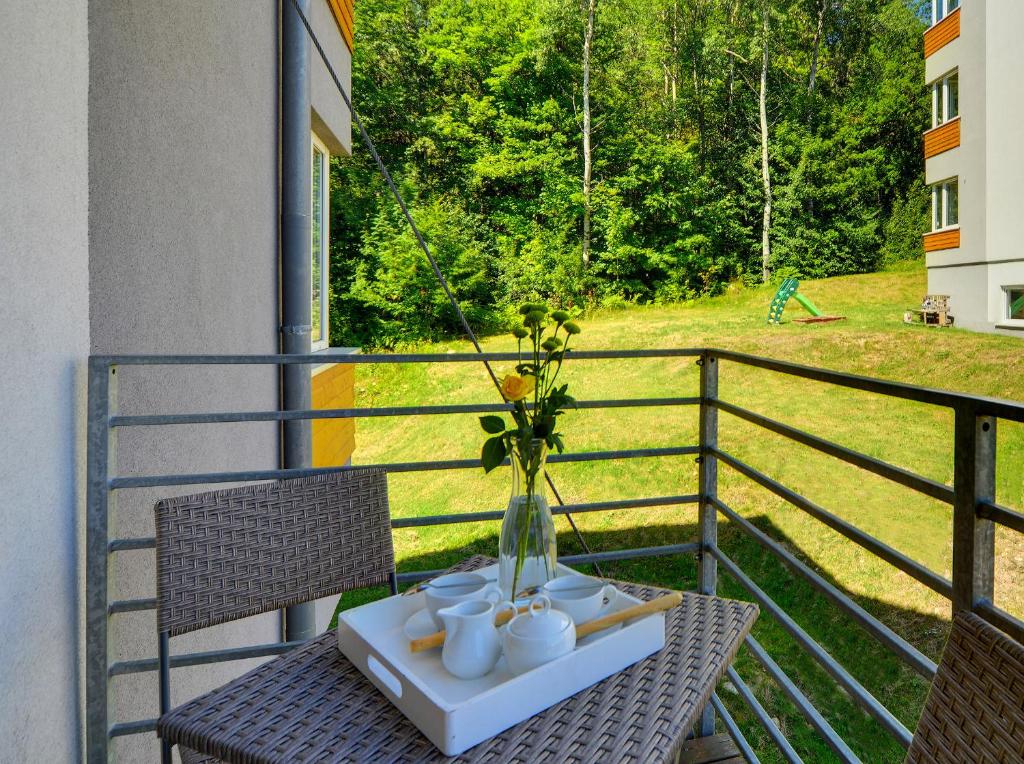 una mesa con un jarrón en el balcón en Apartamenty Sun Seasons 24 - Izery, en Świeradów-Zdrój