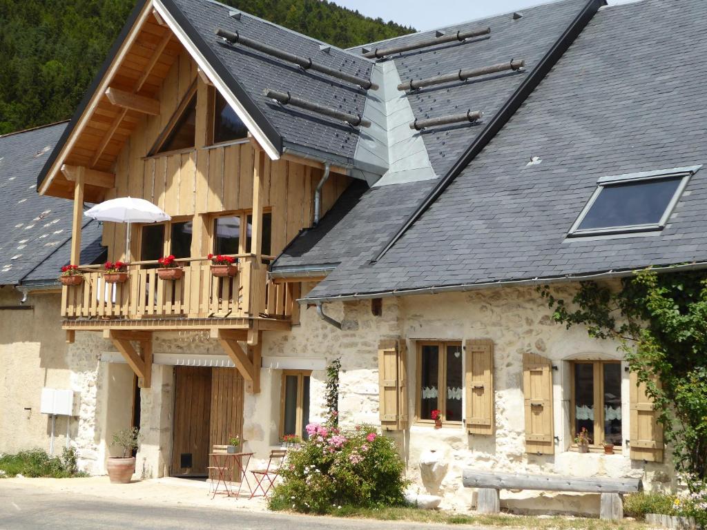 uma casa com uma varanda e um telhado em Ferme de la grande Moucherolle em Villard-de-Lans