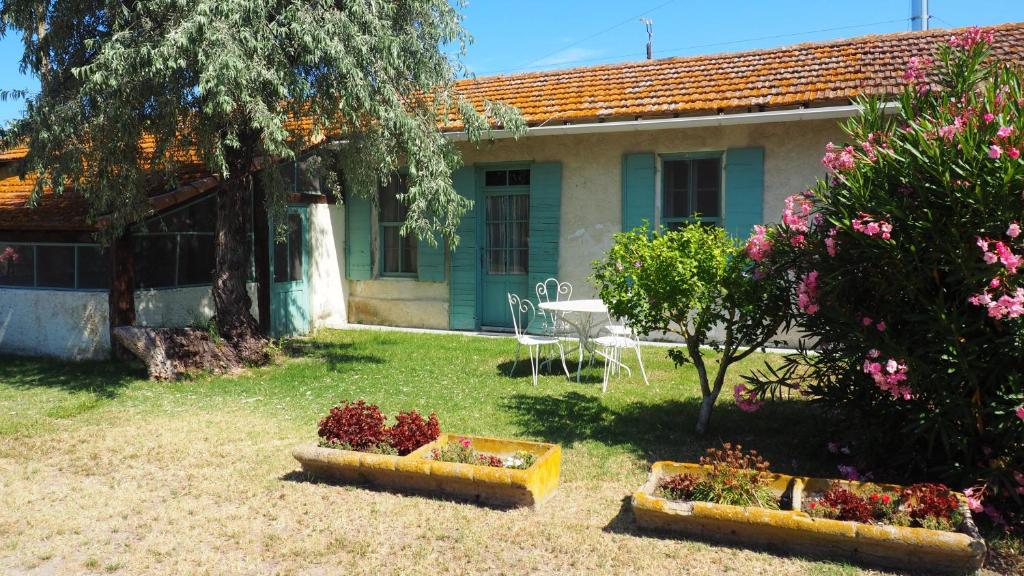 un patio con dos cestas de flores y una casa en Maison de 3 chambres avec piscine partagee et jardin amenage a Saintes Maries de la Mer, en Saintes-Maries-de-la-Mer