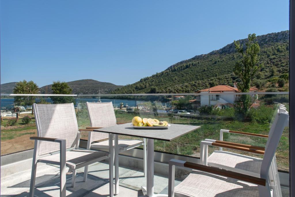 a table and chairs on a balcony with a view at Notia Luxury Living in Porto Koufo