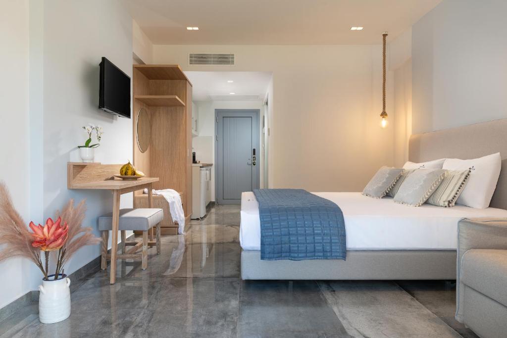 a hotel room with a bed and a table and a desk at Notia Luxury Living in Porto Koufo