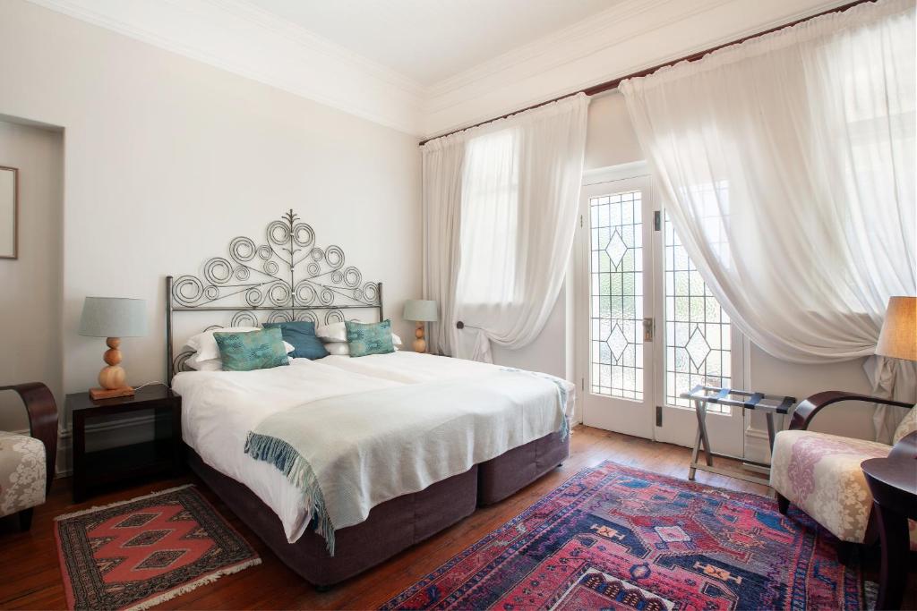 a bedroom with a large bed and a large window at Barry Hall Apartments in Cape Town