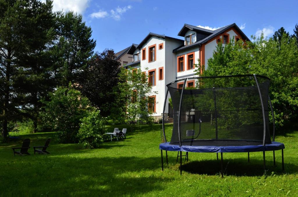 a trampoline in the grass in front of a house at Apartmány Irisis in Chvaleč