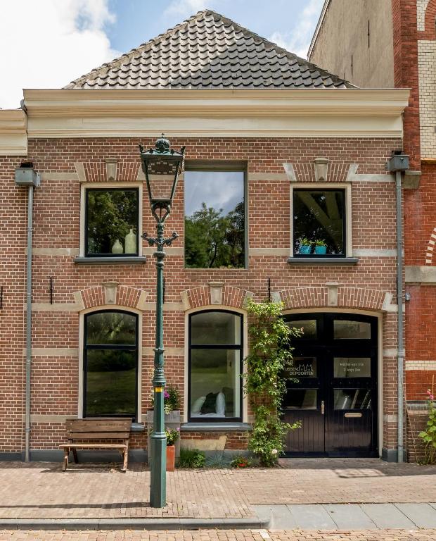 a brick building with a street light in front of it at Bed&Breakfast Tussen de Poorten in Kampen