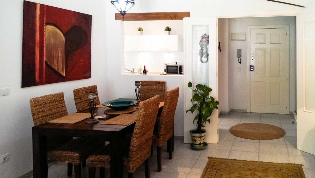 una sala da pranzo con tavolo e sedie in legno di Apartment Las Tres Piedras a Conil de la Frontera