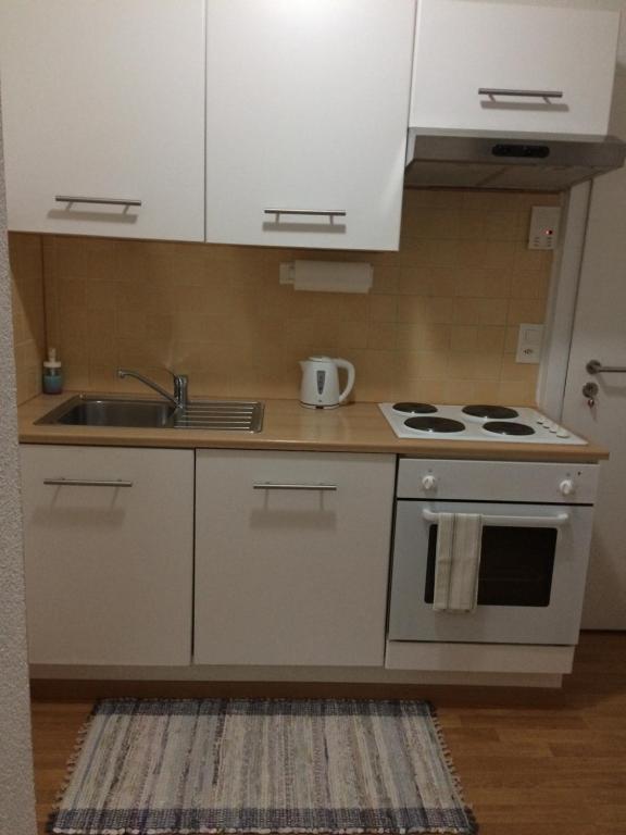 La cuisine est équipée de placards blancs, d'un évier et d'une cuisinière. dans l'établissement 1,5 Zimmer Appartement, à Winterthour