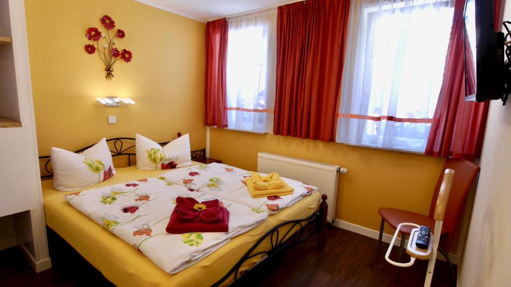 mały pokój z łóżkiem z ręcznikami w obiekcie Pension Metilstein w mieście Eisenach