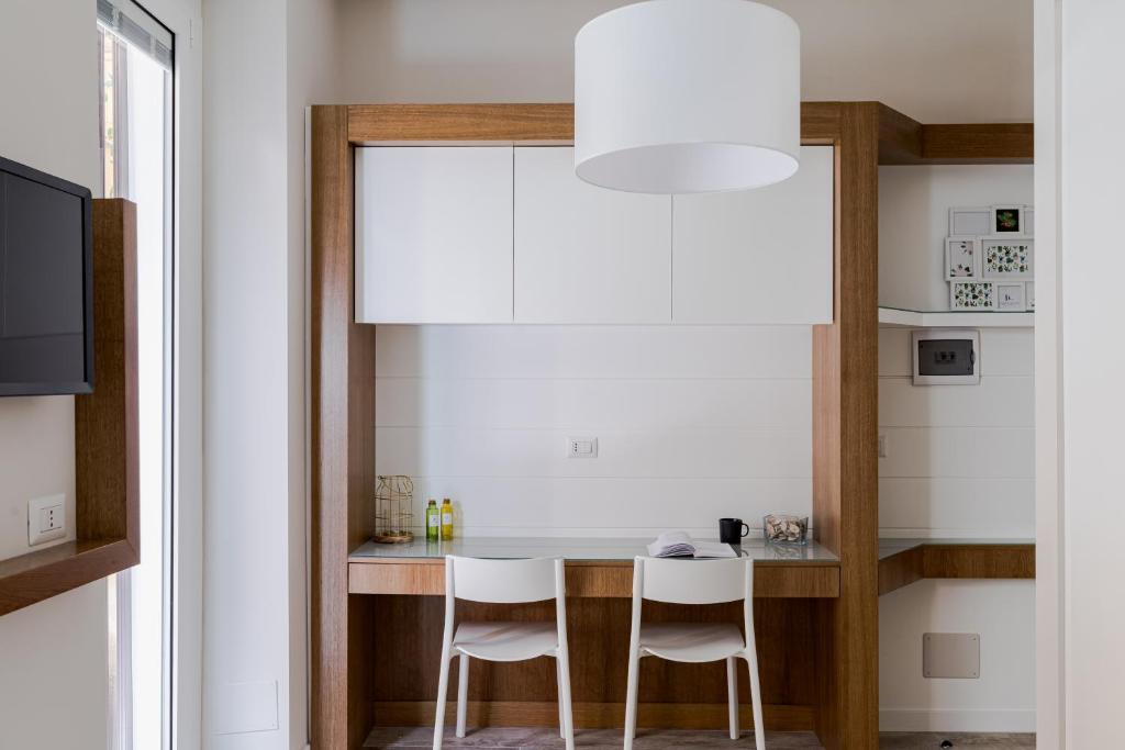 eine Küche mit einem Tisch und 2 weißen Stühlen in der Unterkunft Cavour Luxury Home in Rom
