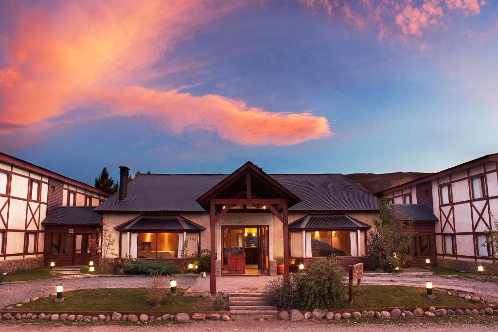 a house with a lit up front yard at dusk at Rincón del Calafate in El Calafate