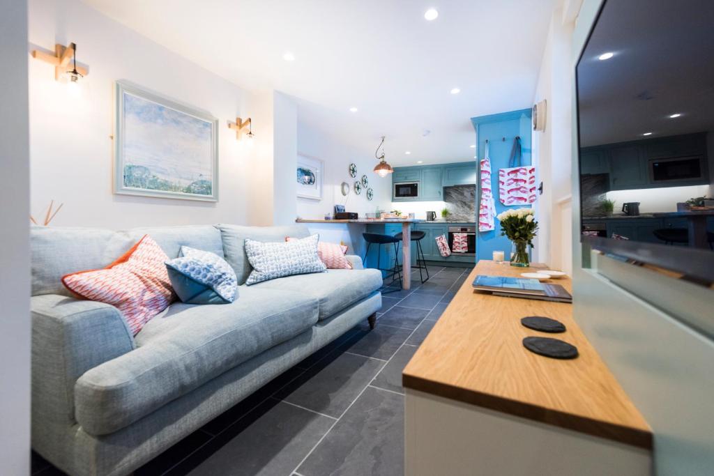 a living room with a couch and a table at Juliot 5 Star Gold Award Luxury Cottage in St Ives