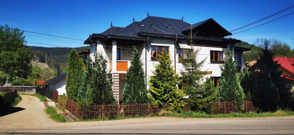 una casa bianca con il tetto nero di Casa Crăciun a Mănăstirea Humorului