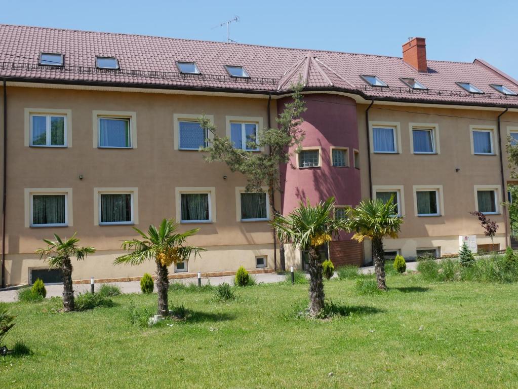 a building with palm trees in front of it at Zajazd Pułaskiego in Konstancin-Jeziorna