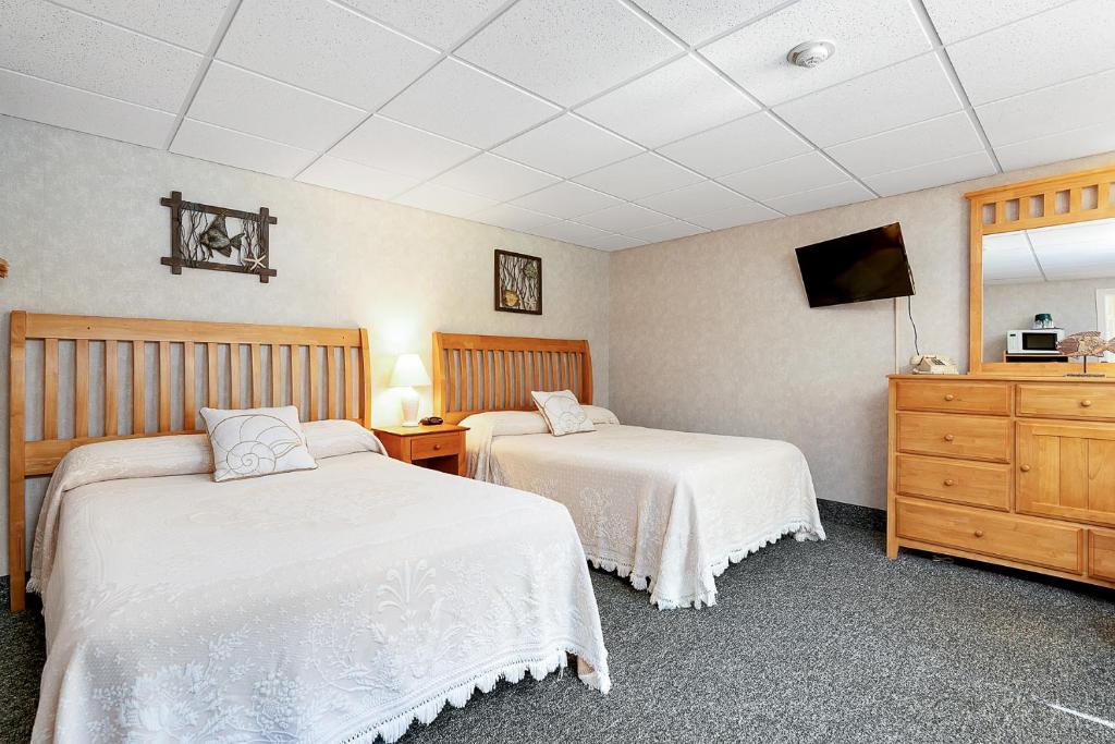 a hotel room with two beds and a dresser at Towne Lyne Motel in Ogunquit