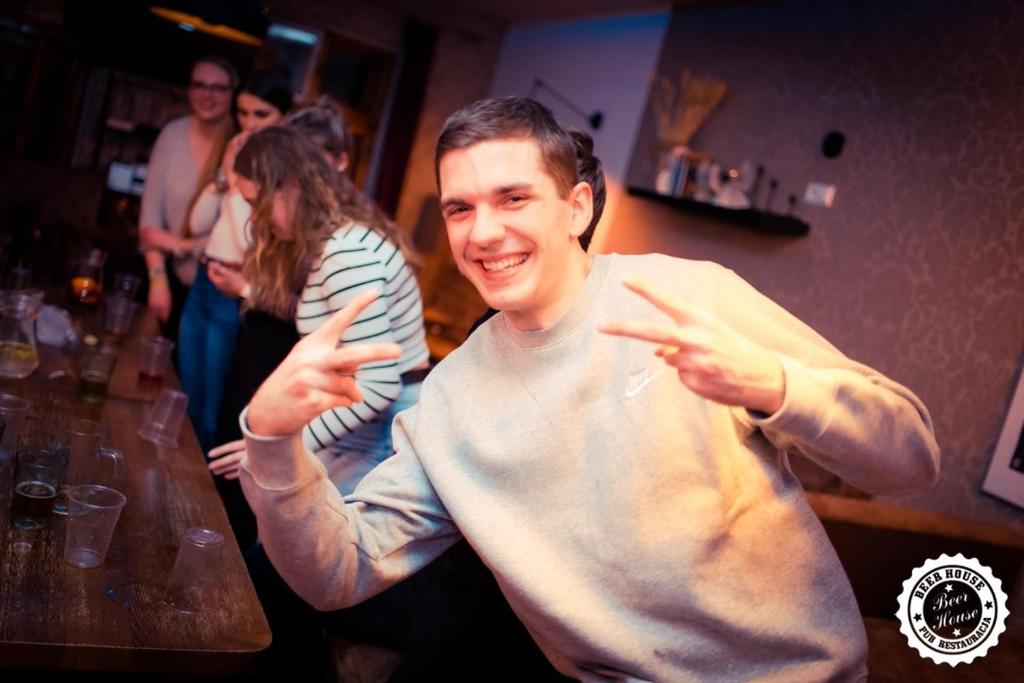 a man holding his hands up in a bar at Greg&Tom Beer House Hostel in Krakow
