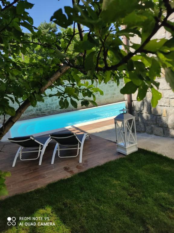 - une piscine avec 2 chaises et une table dans l'établissement Posada Rural La Flor, à Las Navas del Marqués