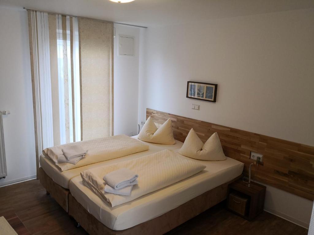 a bedroom with a bed with white sheets and pillows at Gästehaus und Fewo Lamm Garni in Blaubeuren