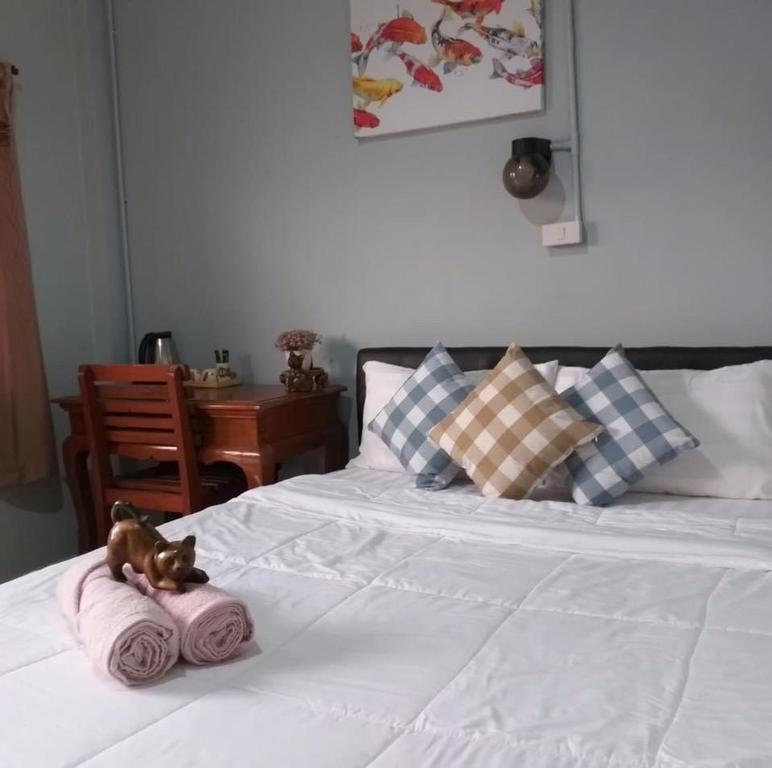 a toy dog sitting on top of a bed at Saming Chiang Dao Guest House in Chiang Dao