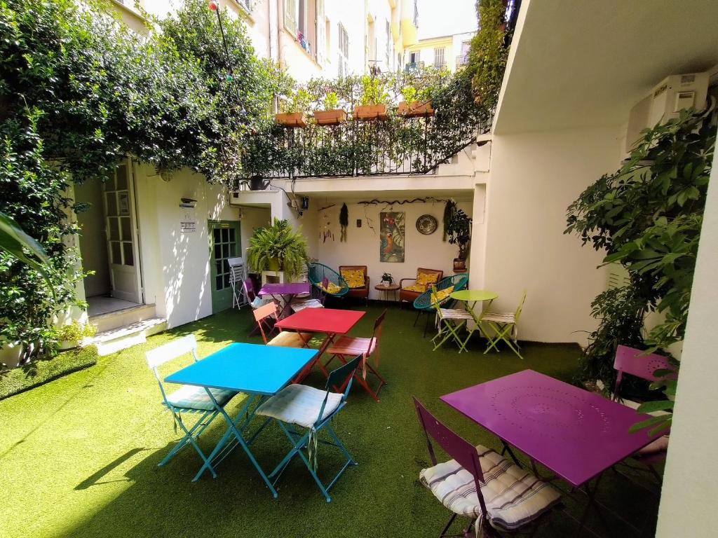 a patio area with chairs, tables, and lawn chairs at Hotel des Dames in Nice