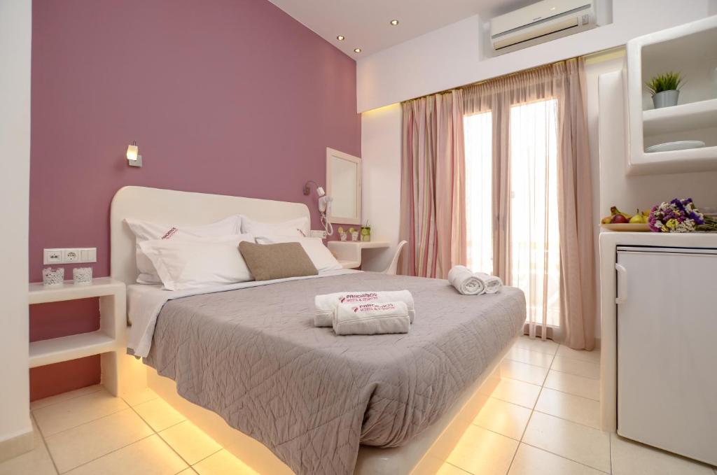 a bedroom with a bed with two towels on it at Panormos Hotel and Studios in Naxos Chora