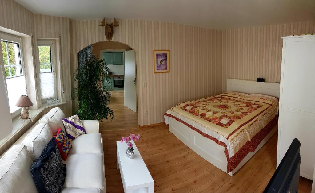 a bedroom with a bed and a couch and a table at Zum Bachhexje in Alken