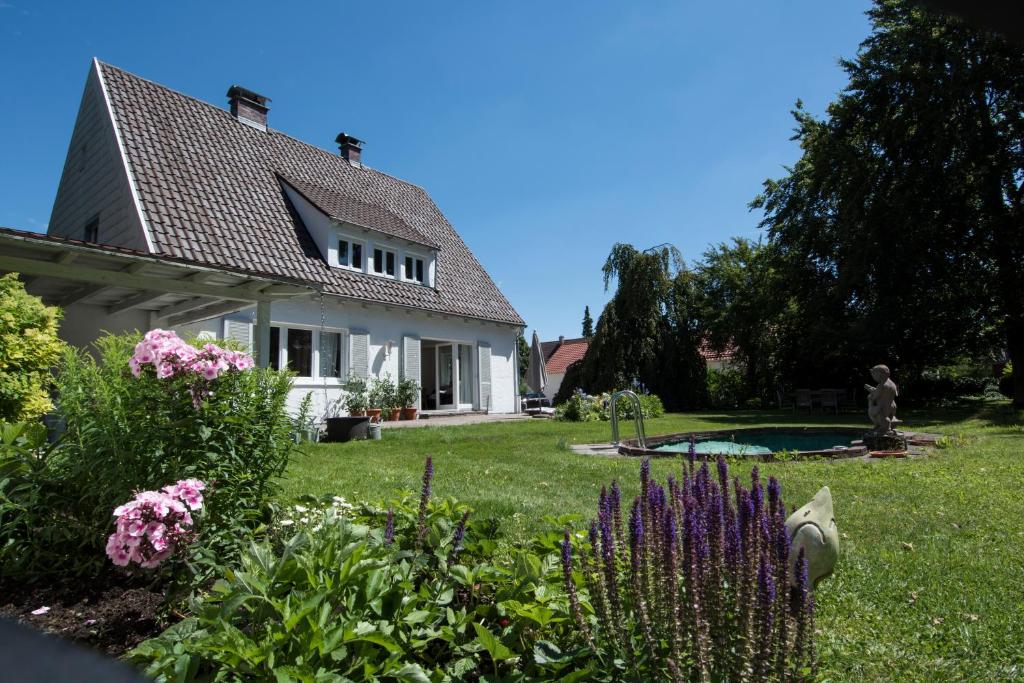 een huis met een tuin en een standbeeld in de tuin bij Haus Hirt - Idyllisch wohnen zwischen Augsburg und München in Klosterlechfeld