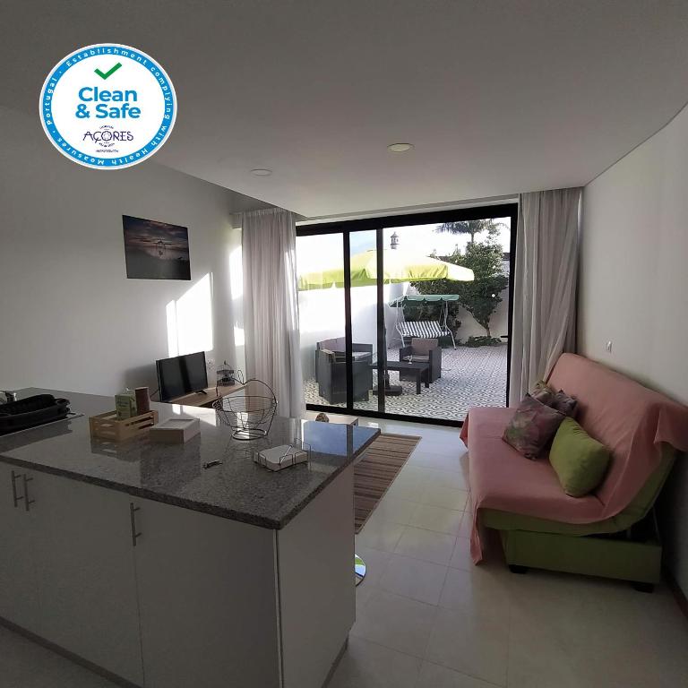 a kitchen and living room with a couch and a table at Helena's House in Ponta Delgada