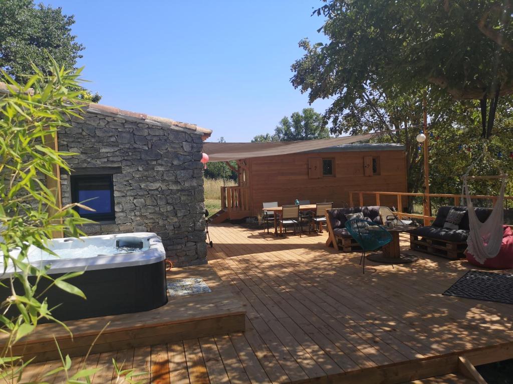 une cour avec un bain à remous et une terrasse dans l'établissement Roulotte la clé du Luberon, à Buoux