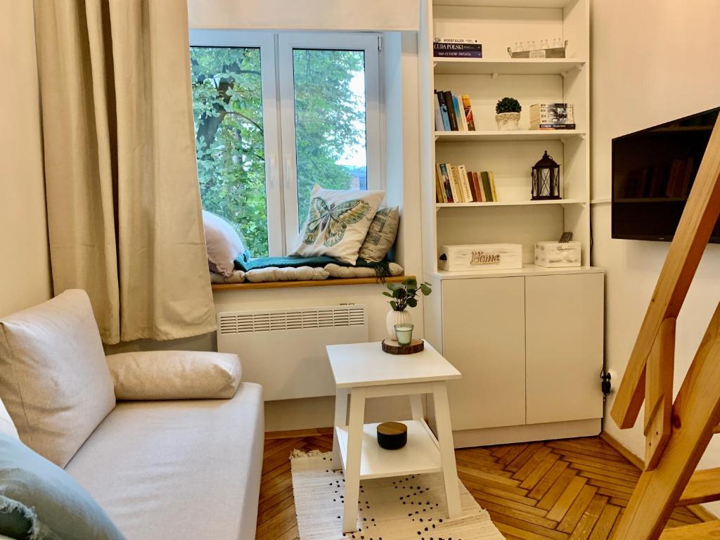 a living room with a couch and a window at Charming Studio in Krakow