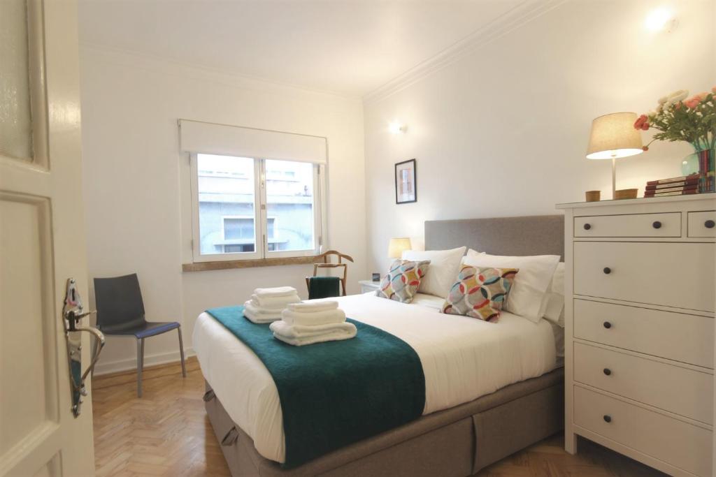 1 dormitorio con 1 cama con toallas en Lisbon Retreat - Entrecampos, en Lisboa