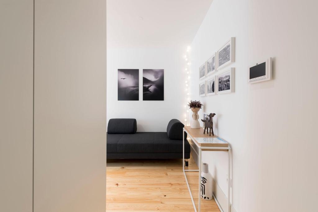 sala de estar con sofá y cuadros en la pared en Heart of D Pedro Apartments, en Oporto