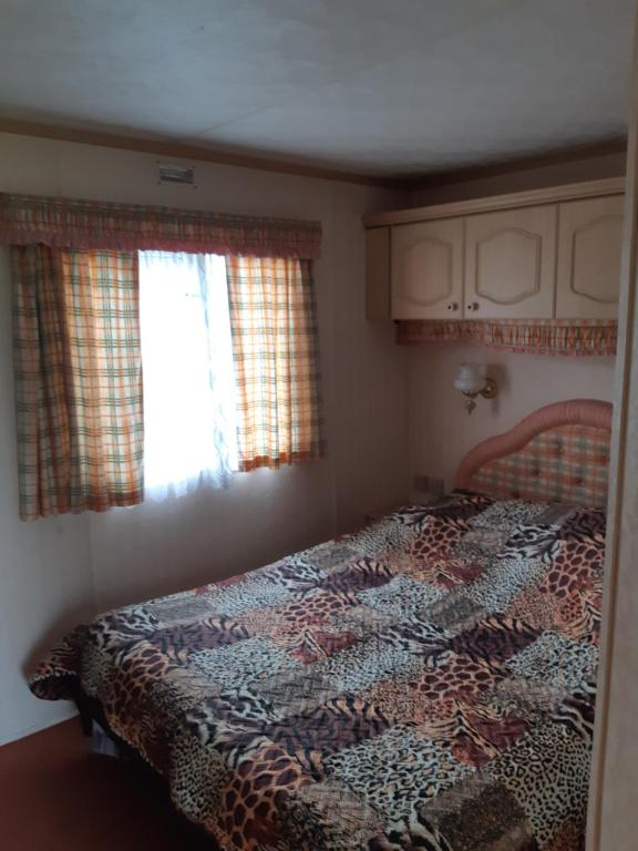 a bedroom with a bed with a patterned quilt at Domek holenderski in Łuka